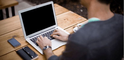 Person working on laptop with AI-assisted reporting interface