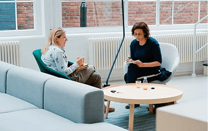 Two business professionals in open office discussing governance