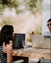 Two colleagues reviewing deliverables at their laptops
