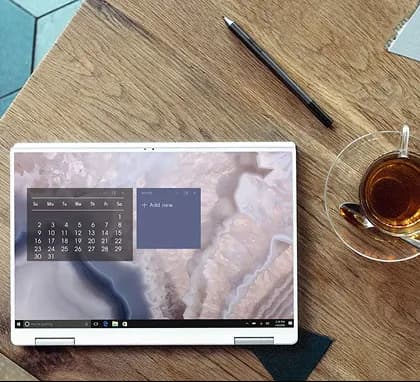 A milestone review open on a laptop beside a cup of tea