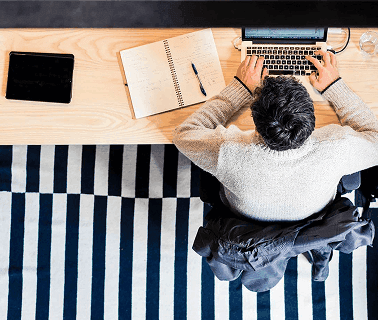 Top-down view of person working at desk defining outputs