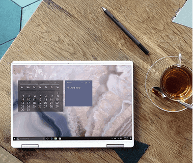 Top-down view of laptop showing calendar and cup of tea