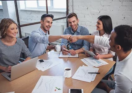 A team celebrating agreement around a table
