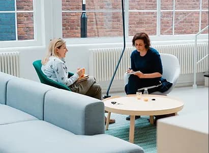Two colleagues reviewing a cancellation request in a lounge